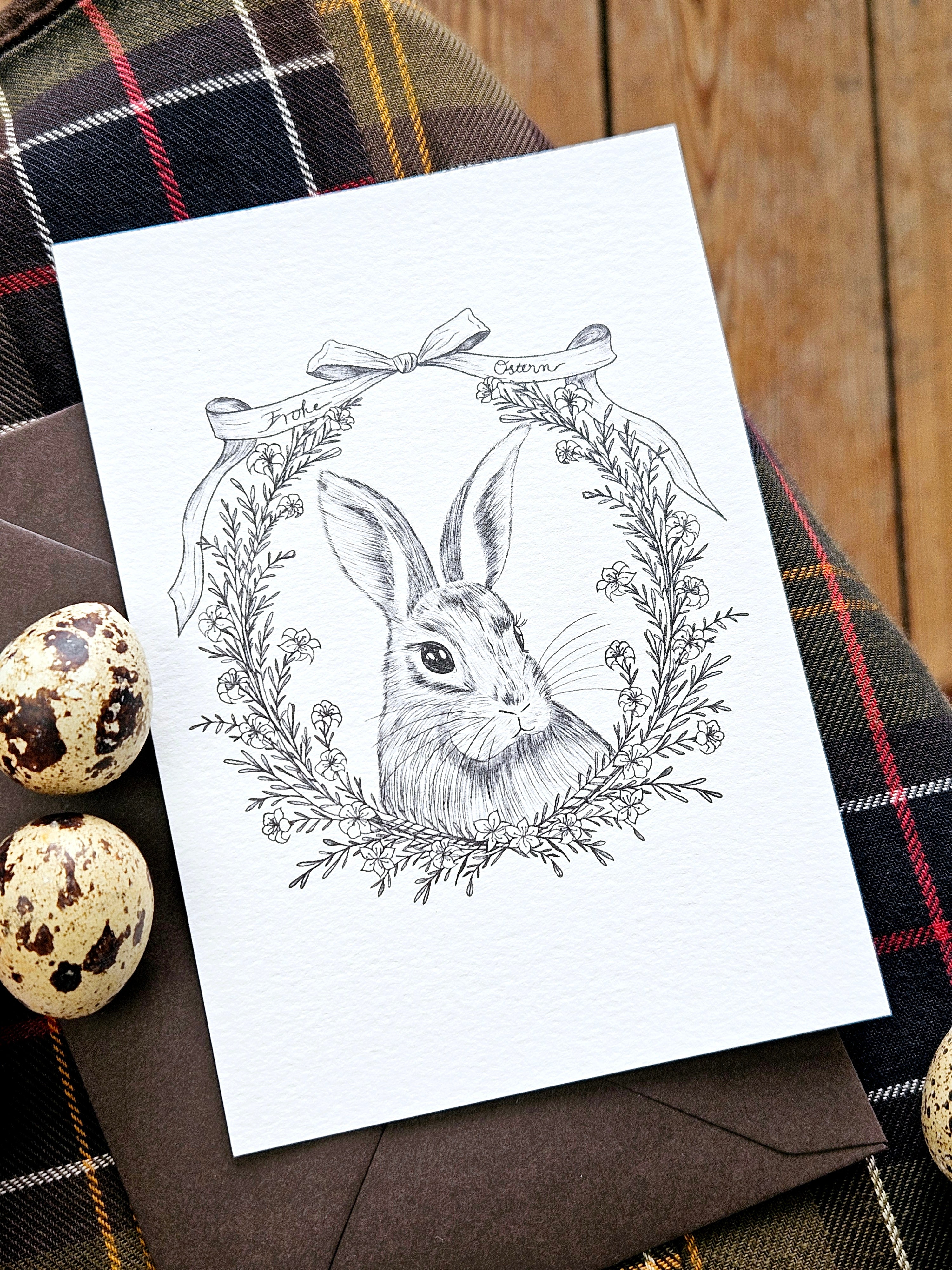 Vintage Osterkarte mit fein illustriertem Hasen und Blütenkranz