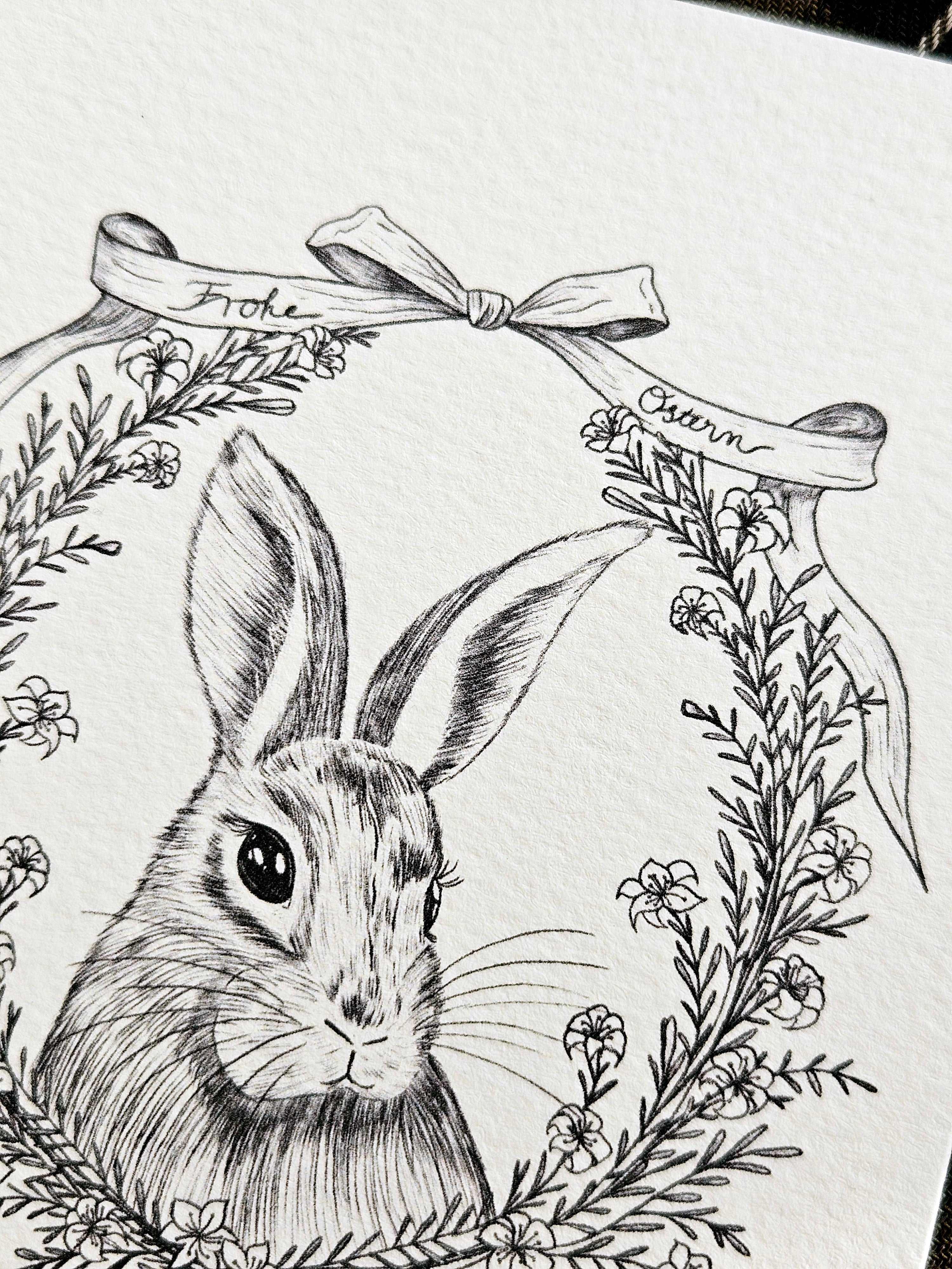 Vintage Osterkarte mit fein illustriertem Hasen und Blütenkranz